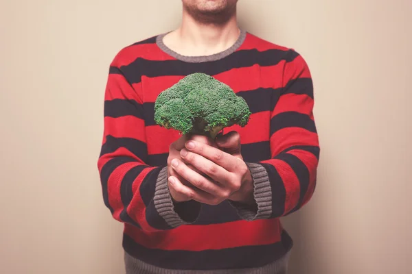 Hombre joven con brócoli —  Fotos de Stock