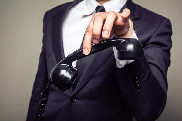 Empresário segurando telefone com os dedos — Fotografia de Stock