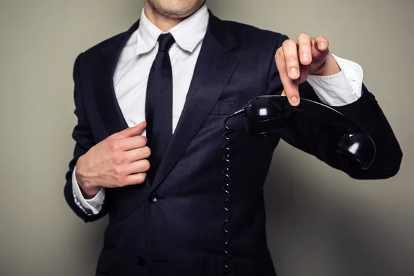 Businessman holding phone with his fingers — Stock Photo, Image