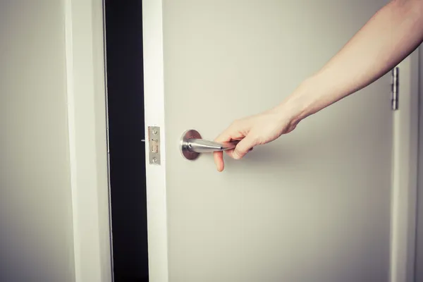 Woman opening a door at night — Stock Photo, Image
