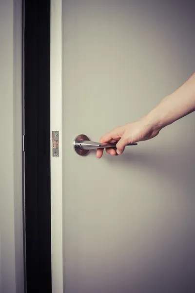 Mulher abrindo uma porta à noite — Fotografia de Stock