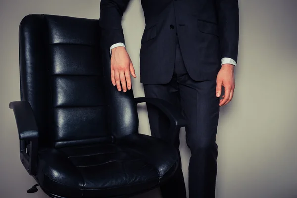 Homme d'affaires debout par chaise de bureau — Photo