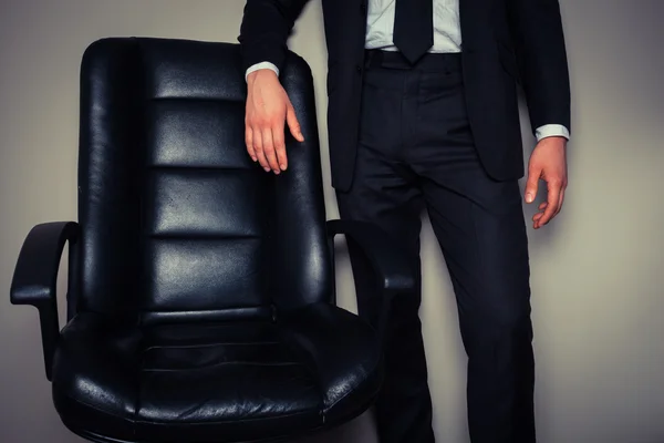 Homme d'affaires debout par chaise de bureau — Photo