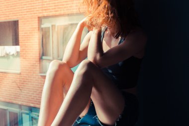 pencerede otururken ve düşünme genç kadın