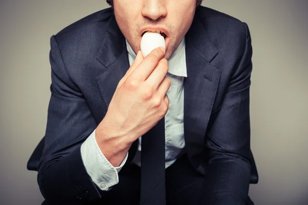 Businessman eating egg — Stock Photo, Image