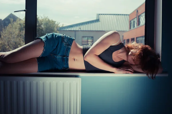 Sexy woman lying in window — Stock Photo, Image