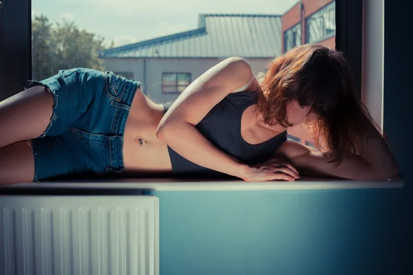 Sexy žena, ležící v okně — Stock fotografie