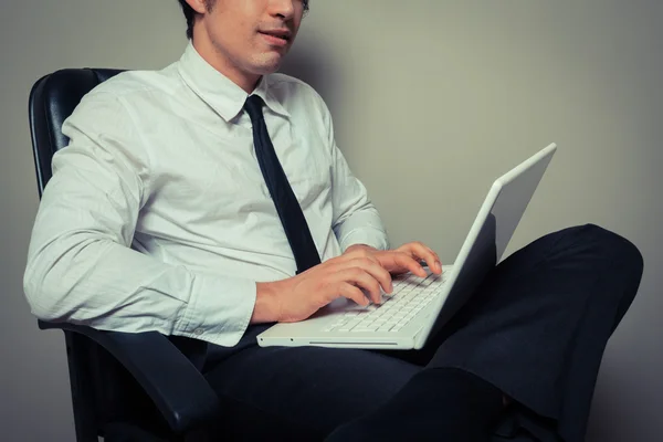 Empresário em cadeira de escritório trabalhando no laptop — Fotografia de Stock