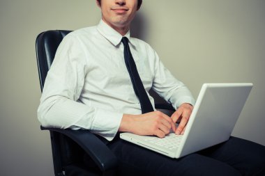 ofis koltuğu dizüstü bilgisayarda çalışan işadamı