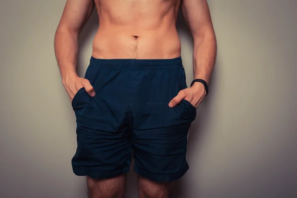 Jonge man knijpen zijn maag past — Stockfoto