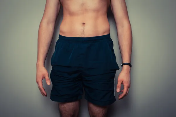 Passen jongeman met afgezwakt maag — Stockfoto