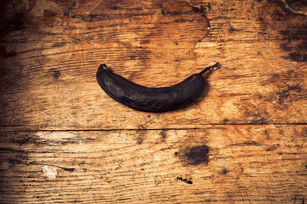 Черный банан на деревянном столе — стоковое фото