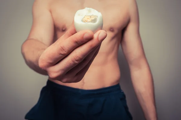 Athletic young man with egg — Stock Photo, Image