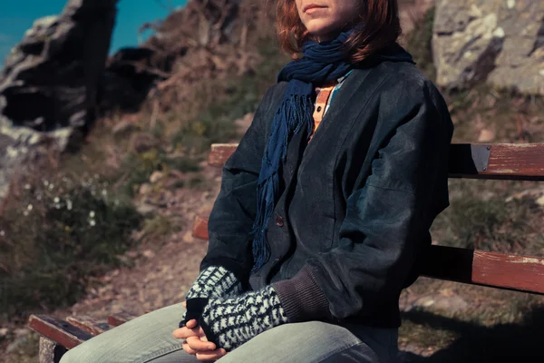 Woman relaxing on a bench in the mountains — Stock Photo, Image