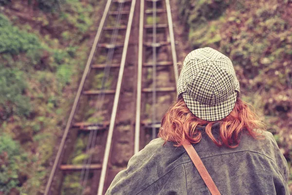 Vrouw op zoek naar een klif spoor — Stockfoto