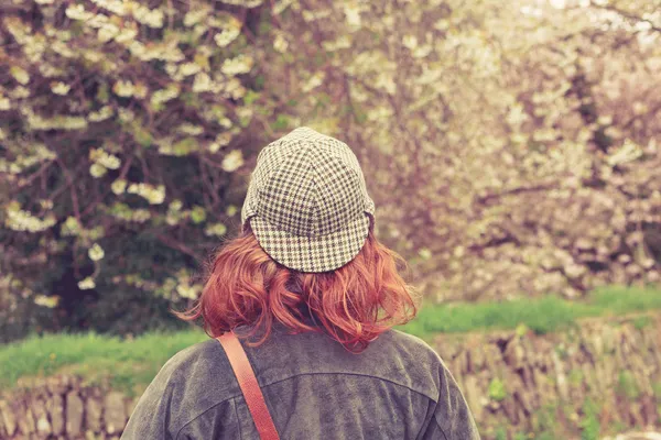 Mulher de chapéu de perseguidor de veados olhando para árvores — Fotografia de Stock