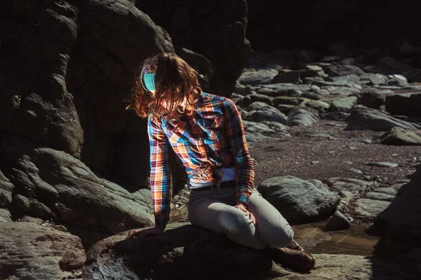 Bir kayanın üzerinde oturan kadın — Stok fotoğraf