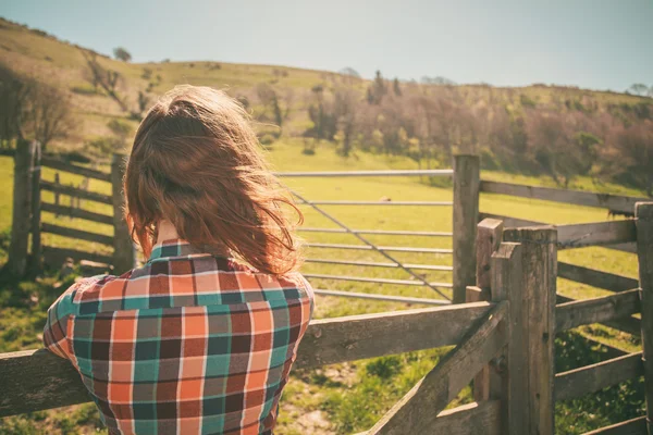 Mladá žena plotem na ranči — Stock fotografie