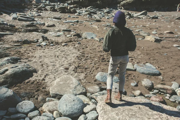 岩の多い地形の上を歩く女性 — ストック写真