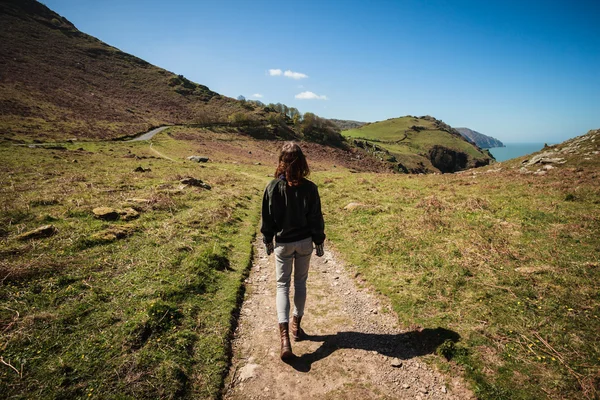 Mujer caminando por el sendero en las montañas — Foto de Stock