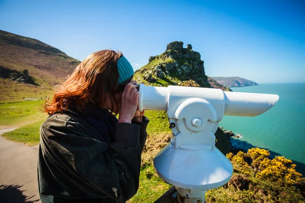 Kobieta szuka przez teleskop nad morzem — Zdjęcie stockowe