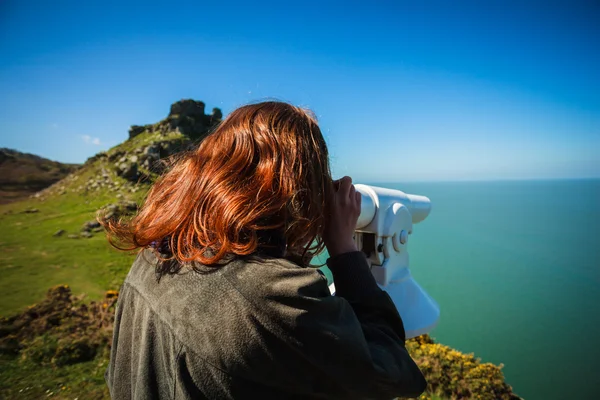 Mujer mirando a través del telescopio junto al mar —  Fotos de Stock