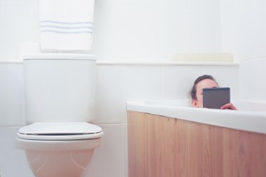 kadın tablete okurken küvet içinde