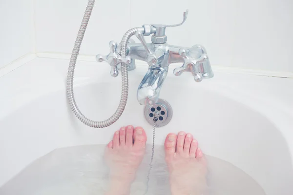 I piedi di una giovane donna nella vasca da bagno — Foto Stock