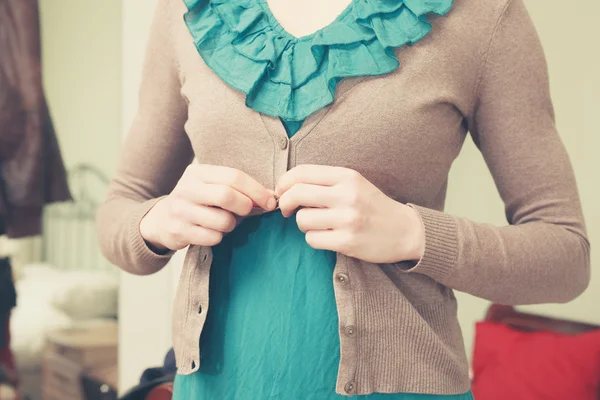 Mujer joven abotonándose la blusa — Foto de Stock