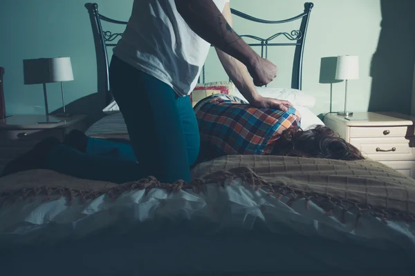 Homme abusant de sa femme sur un lit — Photo