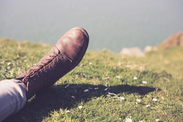 Foot wearing a boot by the sea — Stock Photo, Image