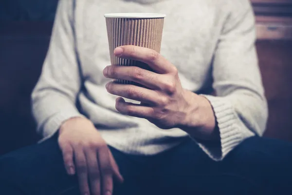 Man met papier beker aanbrengen op sofa — Stockfoto