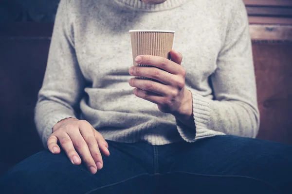 Man med papper cup placering på soffa — Stockfoto