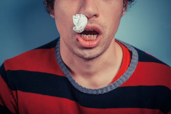 Человек с носовым кровотечением и ледяными язвами — стоковое фото