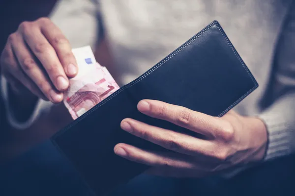 Mann holt Geld aus Geldbörse — Stockfoto