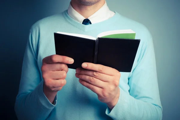 Jongeman met notitieblok openen — Stockfoto