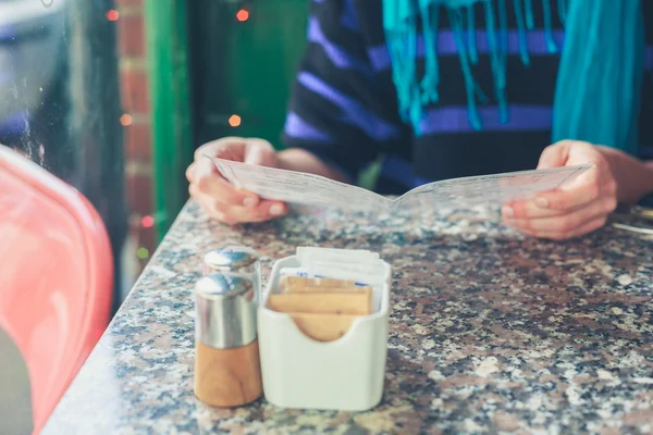 Vrouw studeren menu in een café — Stockfoto