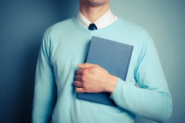 Ung man innehar en stor bok — Stockfoto