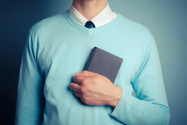 Jonge man geklemd klein notaboekje — Stockfoto