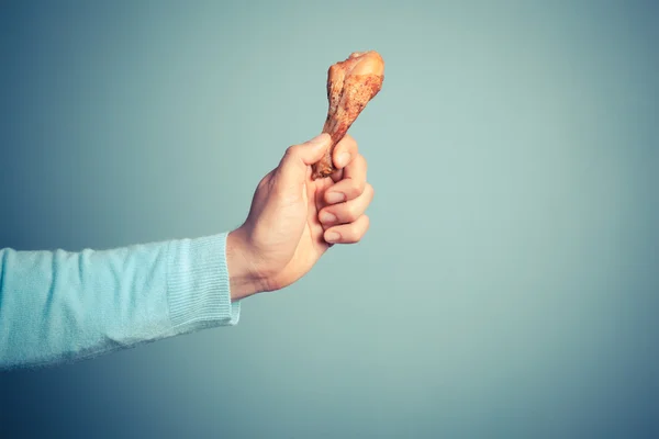 Man holding a chicken drumstick — Stock Photo, Image