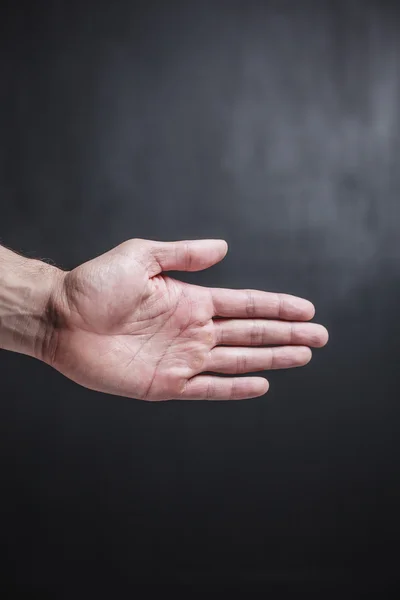 Hand vor schwarzem Hintergrund — Stockfoto