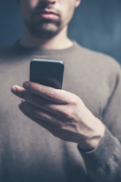 Jeune homme utilisant un téléphone intelligent — Photo