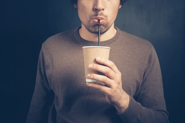 Jeune homme buvant dans une tasse en papier avec de la paille — Photo