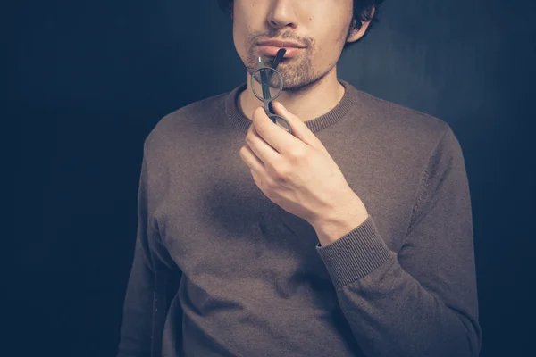 Giovane uomo con gli occhiali sta pensando — Foto Stock