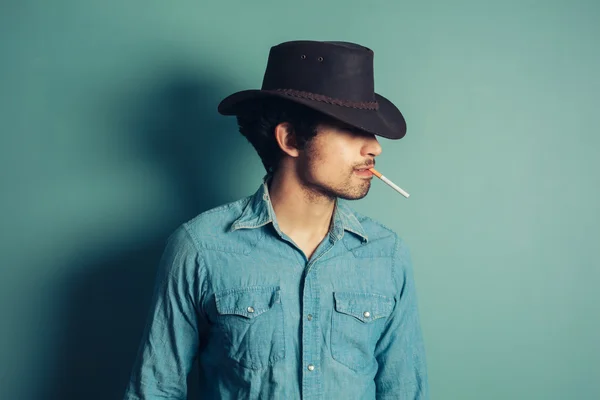 Vaquero joven fumando cigarrillo — Foto de Stock