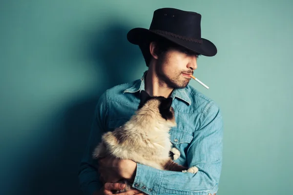 Jonge cowboy met kat is roken — Stockfoto