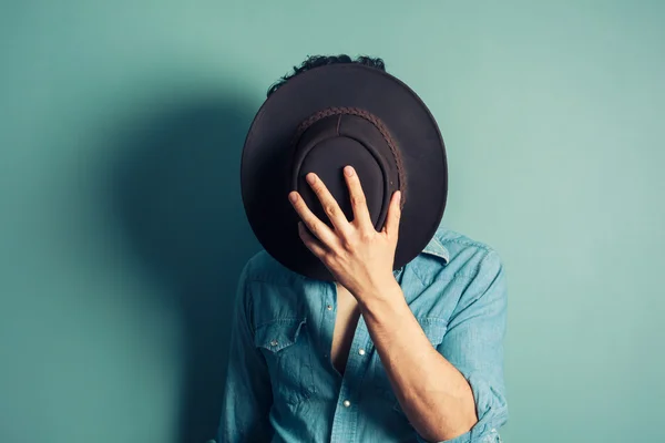 Cowboy hiding behind his hat — Stock Photo, Image