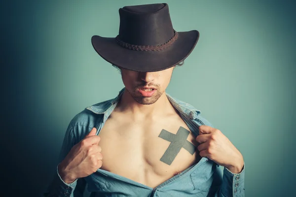 Ung cowboy knäppa upp hans skjorta — Stockfoto