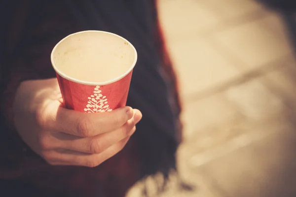 Closeup on a young woman holding a paper cup — Stock Photo, Image