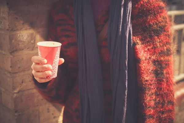 Young woman standing in the street with a paper cup — Stock Photo, Image